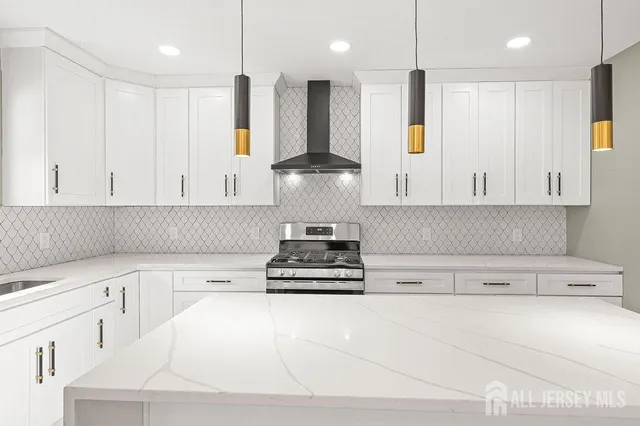 a kitchen with stainless steel appliances granite countertop a refrigerator a sink and white cabinets