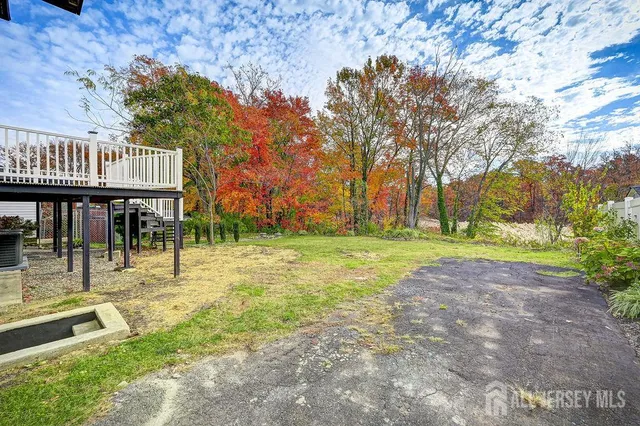 a view of a white house with a big yard and large trees