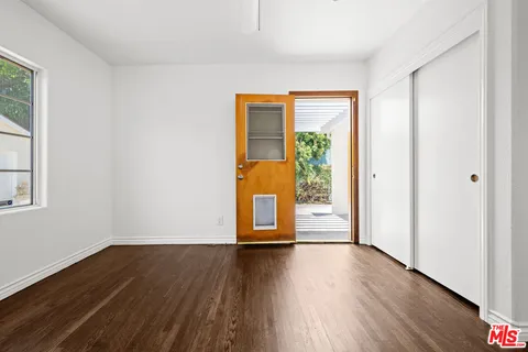 a view of a room with wooden floor and a window