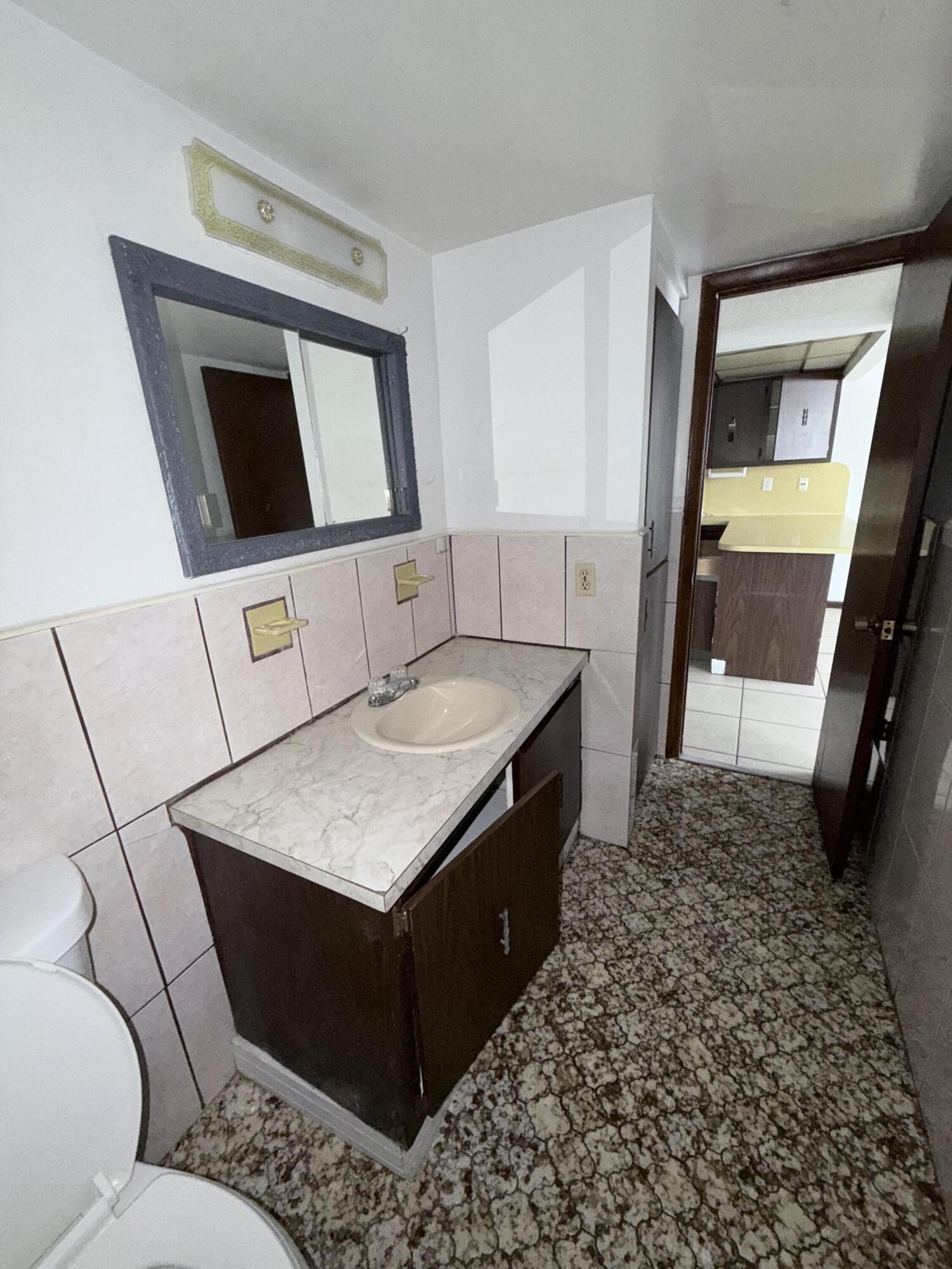 6050 Southwest 27th Street Miramar, FL 33023 - Photo 26 of 40 a bathroom with a sink a toilet and mirror
