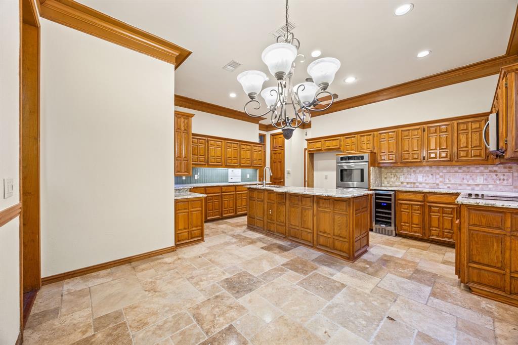 801 Spring Canyon Drive Irving, TX 75063 - Photo 13 of 40 a large kitchen with stainless steel appliances a large counter top a sink and cabinets