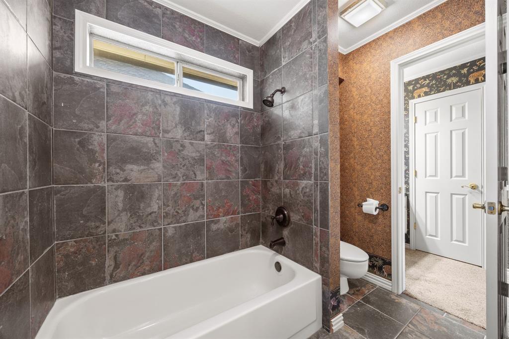 801 Spring Canyon Drive Irving, TX 75063 - Photo 33 of 40 a bathroom with a bathtub and a toilet