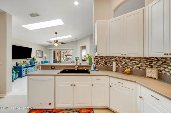 a living room with furniture a chandelier and a flat screen tv