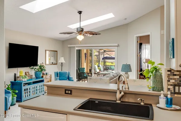 a living room with furniture kitchen view and a potted plant