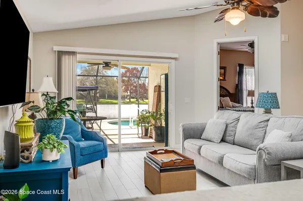a living room with patio furniture and a potted plant