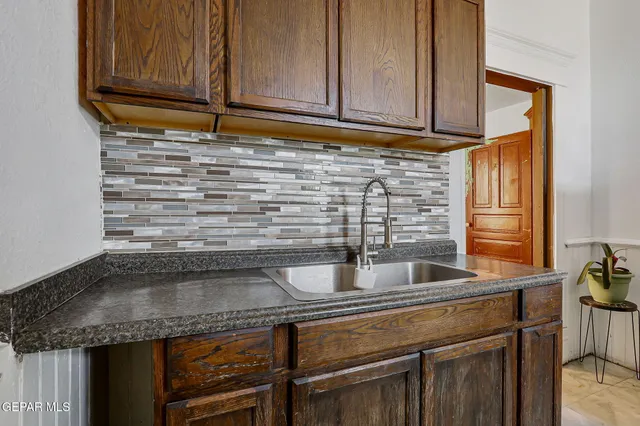 a kitchen with granite countertop a sink and cabinets
