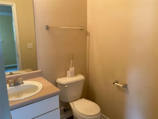 a bathroom with a granite countertop toilet and a sink