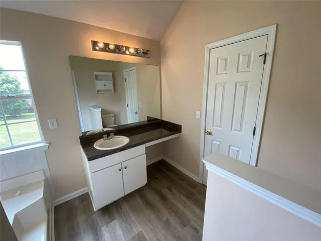 a bathroom with a granite countertop sink toilet and tub