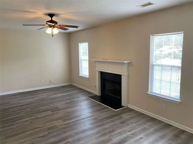 wooden floor fireplace and windows in an empty room
