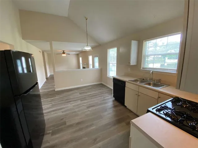 a kitchen with stainless steel appliances granite countertop a sink stove and wooden floor