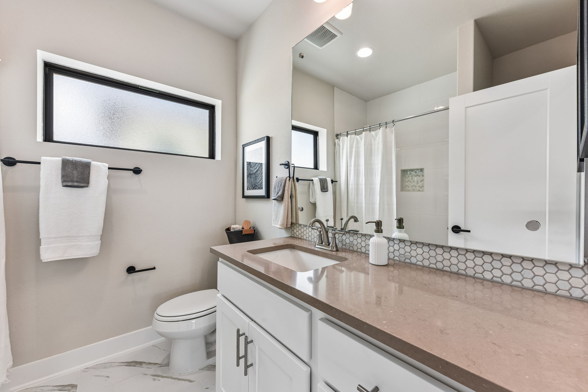 9101 Cattle Baron Path Austin, TX 78747 - Photo 29 of 40 Refined bathroom with sleek vanity, hexagon tile backsplash, and ample illumination.