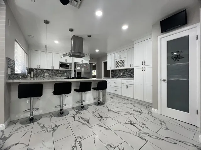 a kitchen with stainless steel appliances kitchen island granite countertop a sink and cabinets