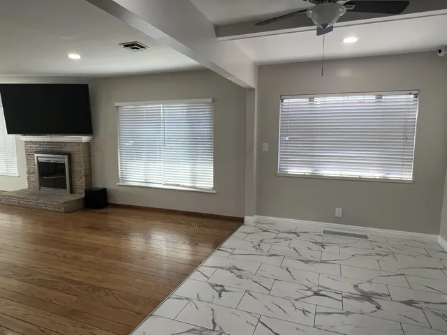 a view of livingroom with flat screen tv wooden floor and window