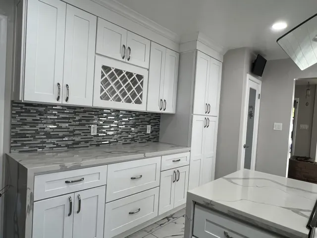 a kitchen with granite countertop white cabinets and sink