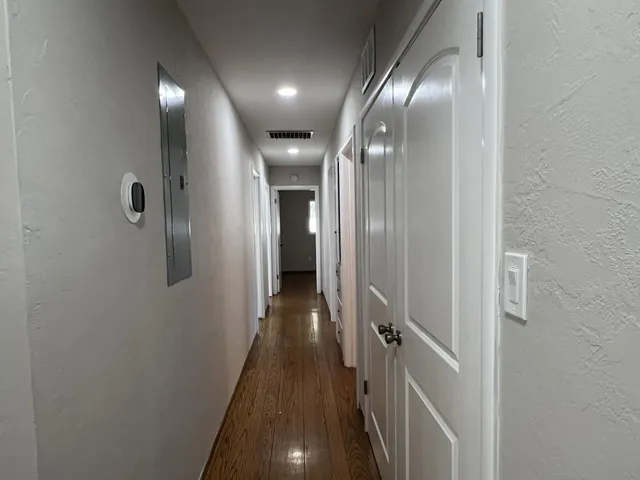 a view of a hallway with wooden floor