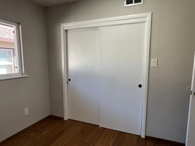 a view of small space with wooden floor and a window