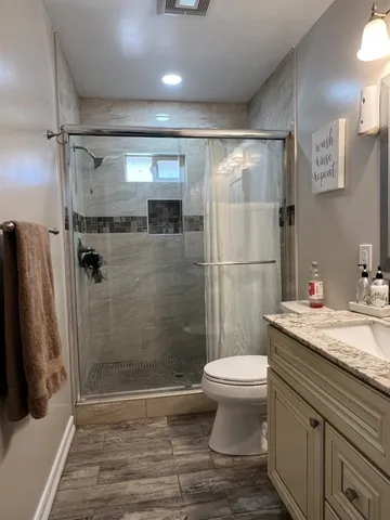 a bathroom with a granite countertop sink toilet and shower