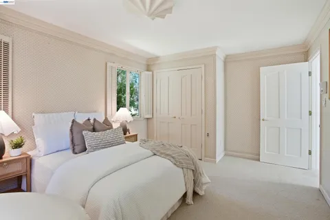 a spacious bedroom with a large bed and a chandelier