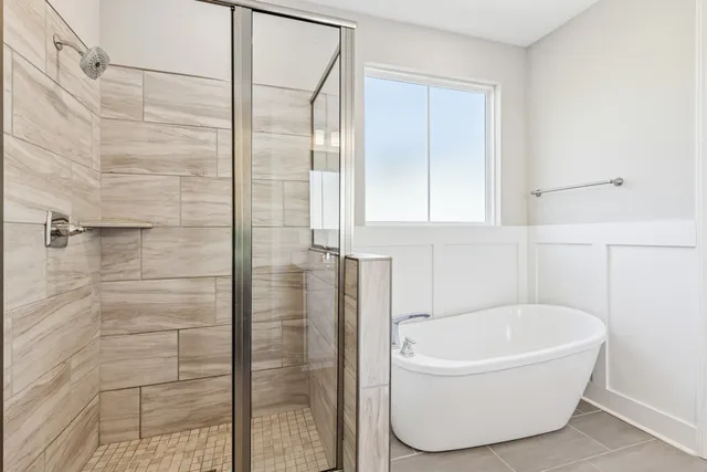 a bathroom with a white tub and shower