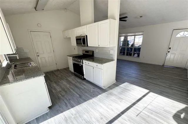 a kitchen with wooden floors and white appliances