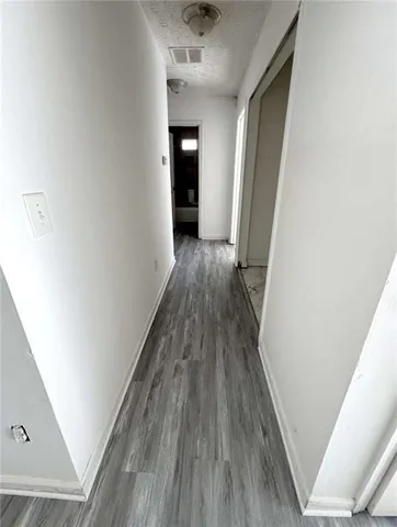 a view of a hallway with wooden floor and a ceiling fan
