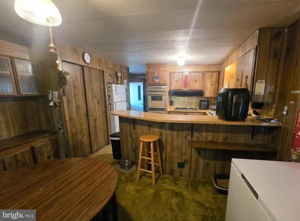 a kitchen with a table chairs refrigerator and microwave