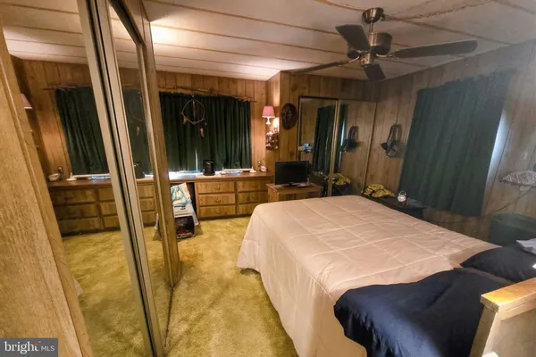 a bedroom with a bed a mirror and a walk in closet