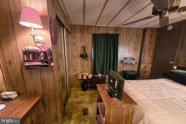 a bedroom with a bed a dresser and a mirror