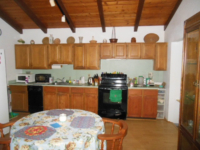 705 Haiku Road Haiku, HI 96708 - Photo 20 of 22 a kitchen with granite countertop a stove and a wooden cabinets