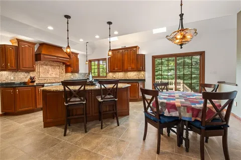 a dining room filled chandelier and wooden furniture