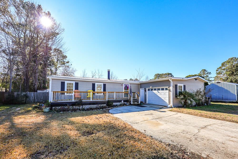 View of front of home featuring concrete driveway, an attached garage, and a wooden deck