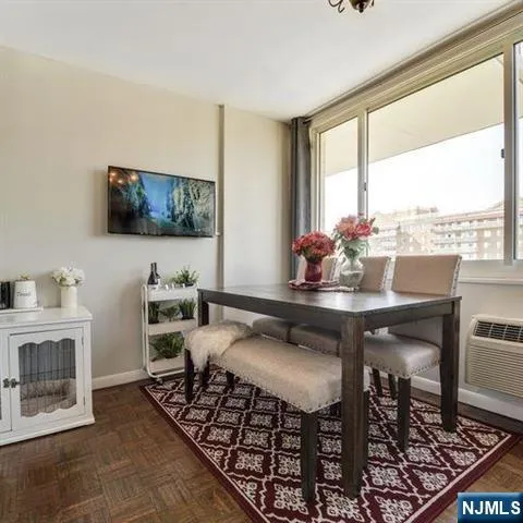 a living room with furniture a flat screen tv and a floor to ceiling window