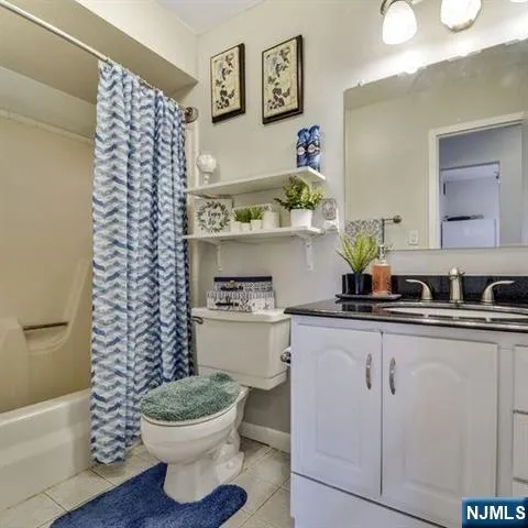 a bathroom with a granite countertop toilet and a sink