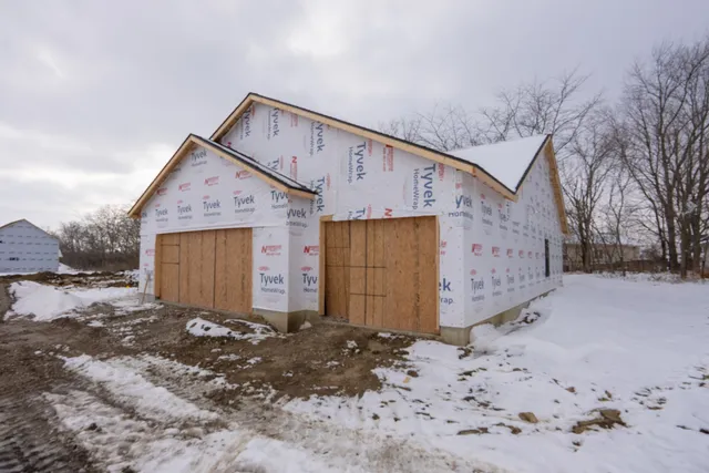 a view of a house with a yard covered in snow