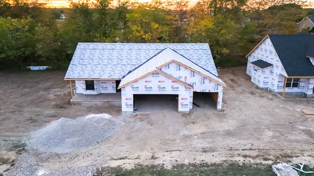 a view of a small house with a yard and roof