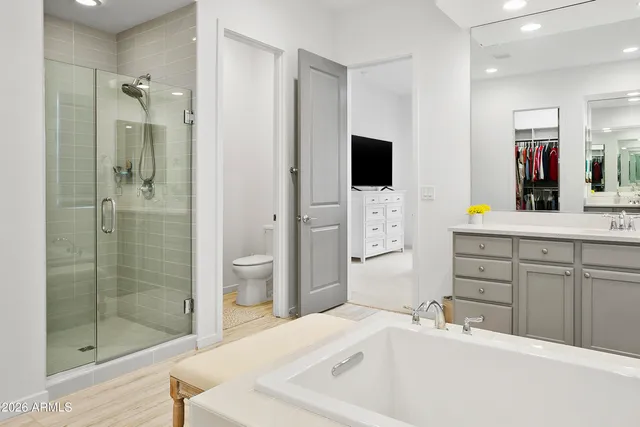 a en suite spacious bathroom with a granite countertop sink mirror and shower