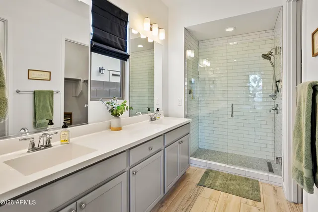 a bathroom with a double vanity sink mirror and shower