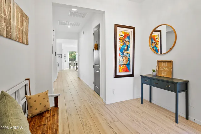 a view of a hallway with wooden floor and entryway