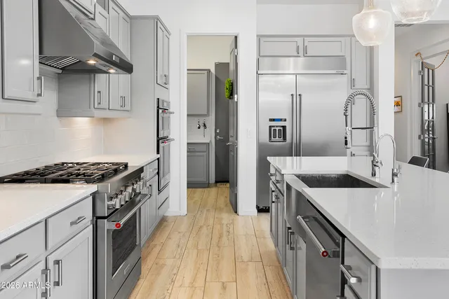 a kitchen with stainless steel appliances granite countertop a sink stove and refrigerator