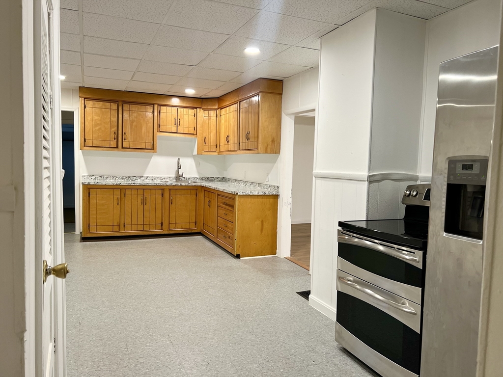 47 Lansing Place, Unit 1 Springfield, MA 01108 - Photo 2 of 10 a kitchen with granite countertop a refrigerator and a sink
