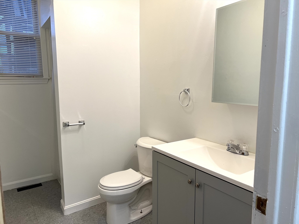 47 Lansing Place, Unit 1 Springfield, MA 01108 - Photo 3 of 10 a bathroom with a sink a toilet and mirror