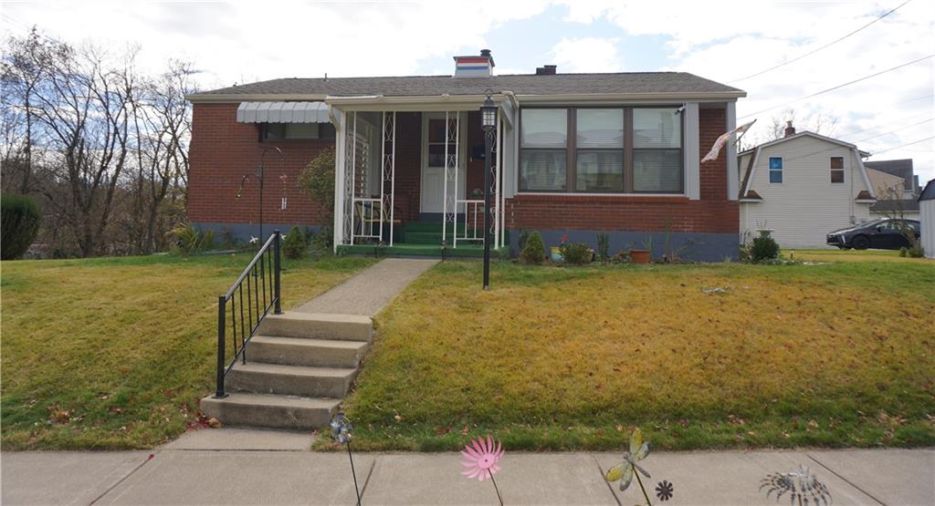 a view of a house with a yard and sitting area