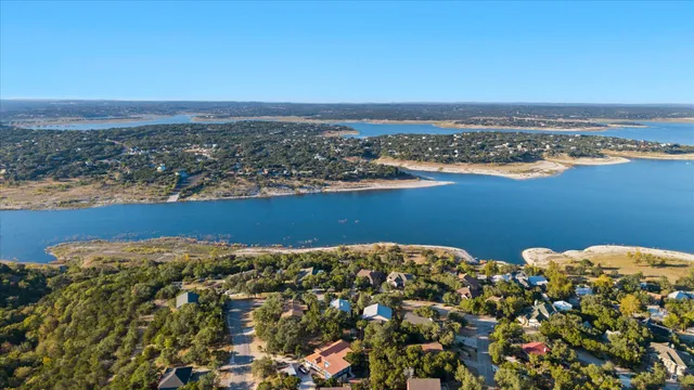 an aerial view of ocean and residential houses with outdoor space