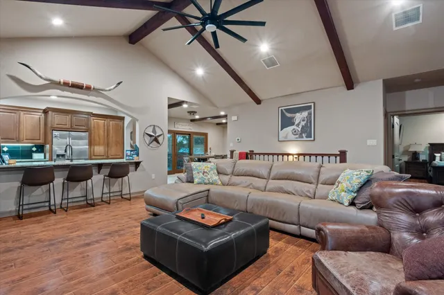 a living room with furniture a ceiling fan and a large window
