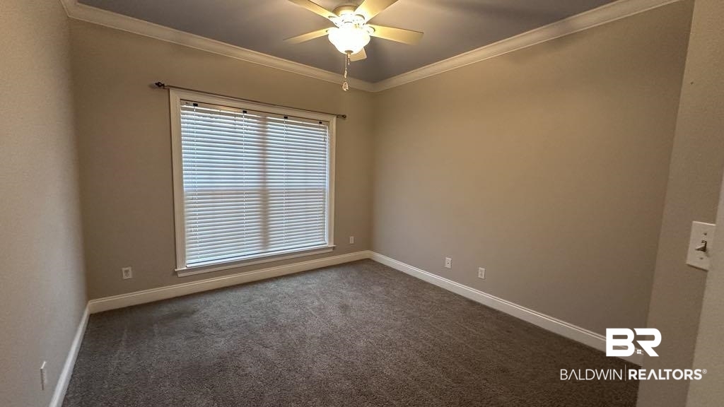 23289 McPhillips Road Loxley, AL 36551 - Photo 12 of 19 Spacious room featuring neutral wall tones, crown molding, a ceiling fan with light fixture, and a large window with blinds