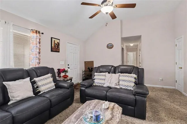 a living room with furniture and a ceiling fan
