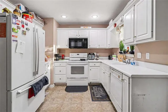 a kitchen with white cabinets and white appliances