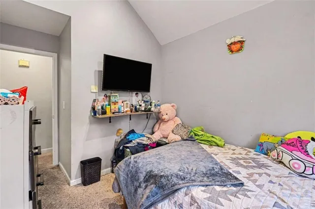 a bedroom with a bed a flat screen tv and a couch