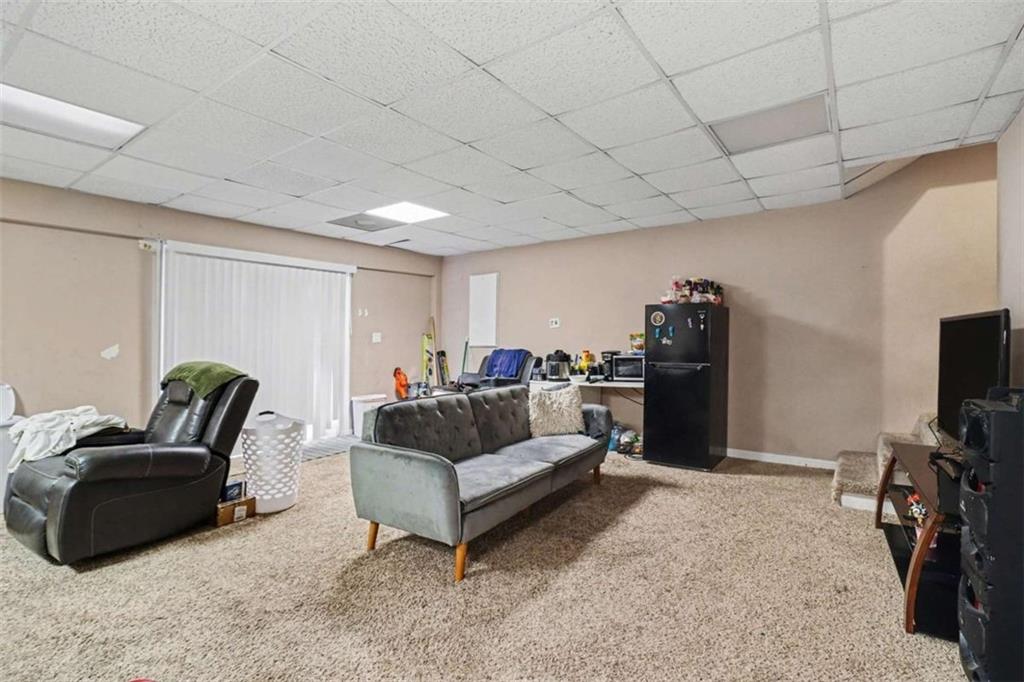 211 Stoney Point Cove Carrollton, GA 30116 - Photo 25 of 38 a living room with furniture a flat screen tv and gym equipment
