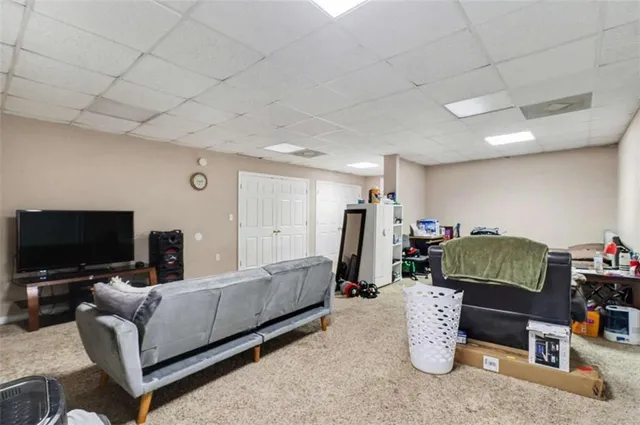 a living room with furniture a flat screen tv and a window